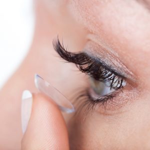 Woman eye with contact lens applying, macro